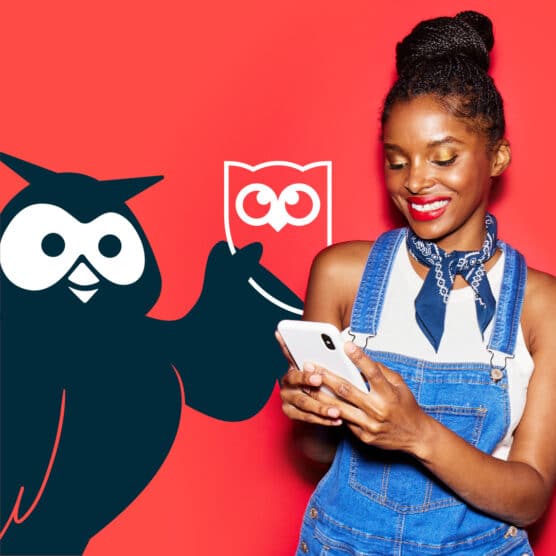 足彩188hootsiti的吉祥物Owly持有公司标识老版,与手机上一个女人并发