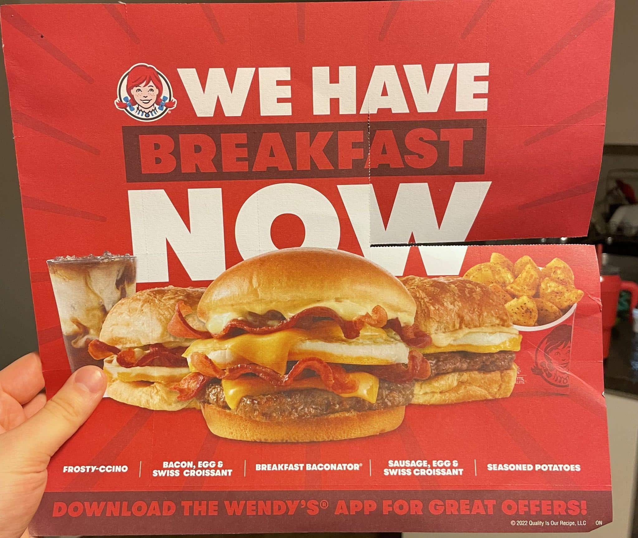 Ein Wendy's-flyer-Flyer MitVerschiedenenFrühstücksangeboten。der text lautet“ wir haben jetztfrühstück”。